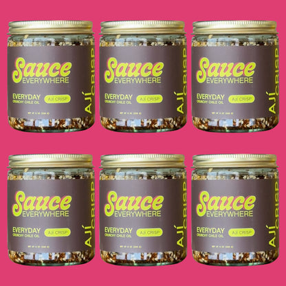 Six glass jars of Aji Crisp chile sauce by Sauce Everywhere against rose background.