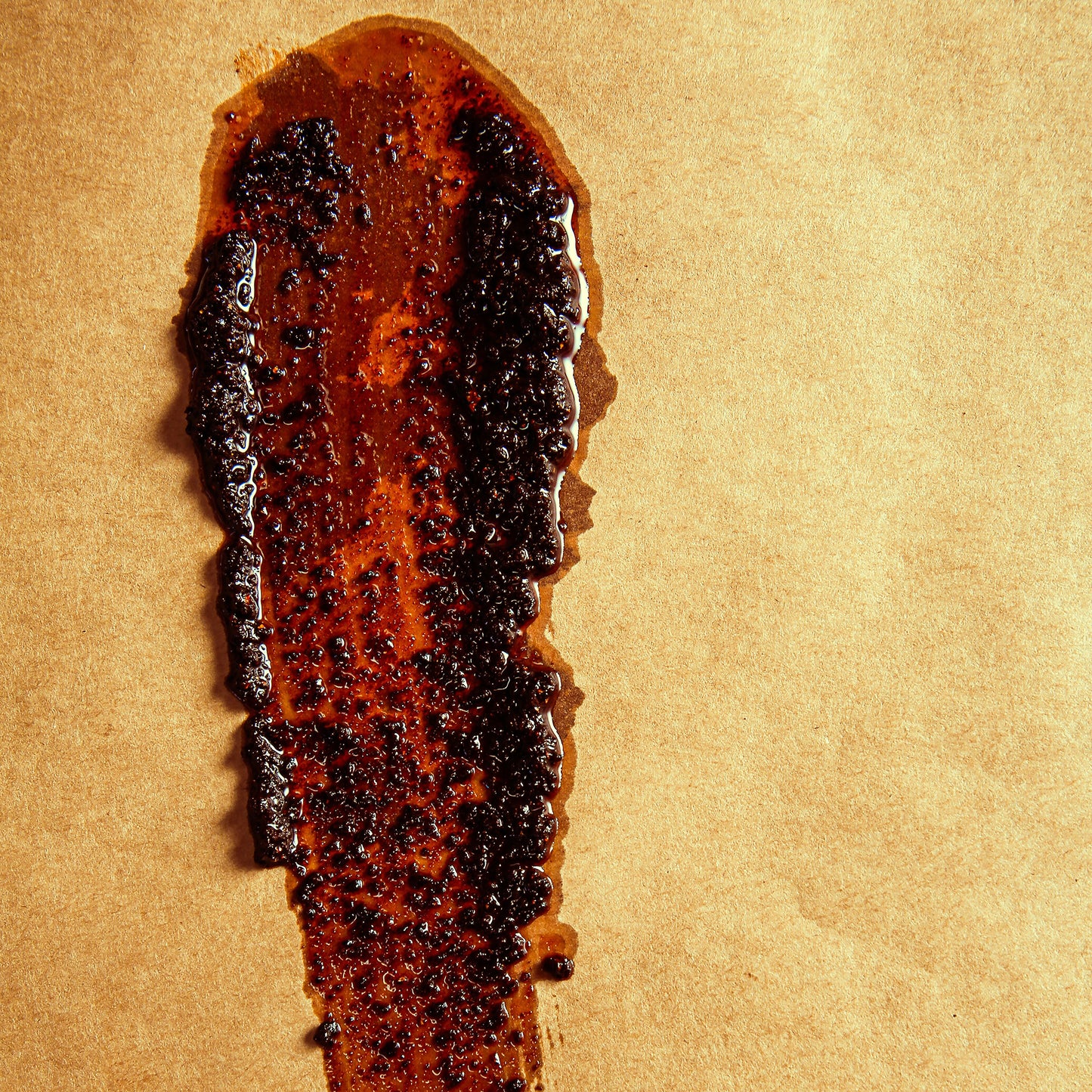 Reddish-black Negra sauce with thick consistency smeared on butcher paper.